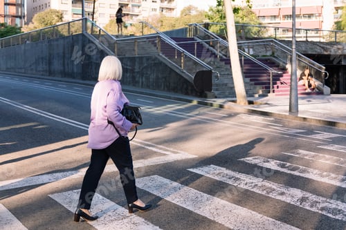 Preview: senior woman crossing a city street