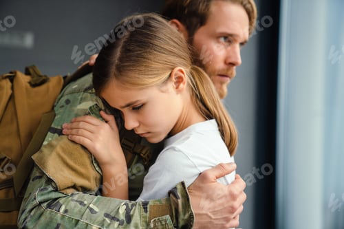 Preview: Masculine sad military man hugging her daughter indoors
