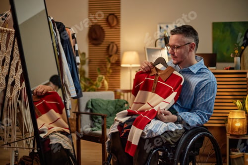 Preview: Middle Aged Caucasian Man with Disability Inspecting Second Hand Sweater