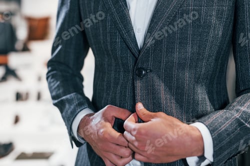 Preview: Close up view. Young guy in modern store with new clothes. Elegant expensive wear for men
