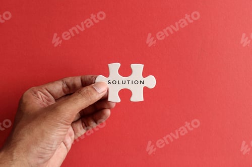 Preview: Hand holding puzzle pieces with text SOLUTION on red background