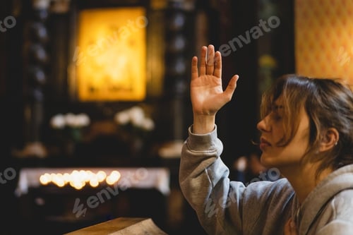 Preview: Woman praying on her knees in an ancient Catholic temple to God.