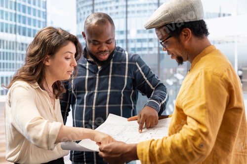 Preview: Business partners touring an office space with realtor and layout plans