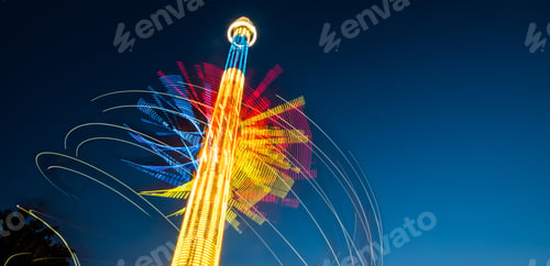 Preview: Abstract colorful traces of carousel in front of dark sky