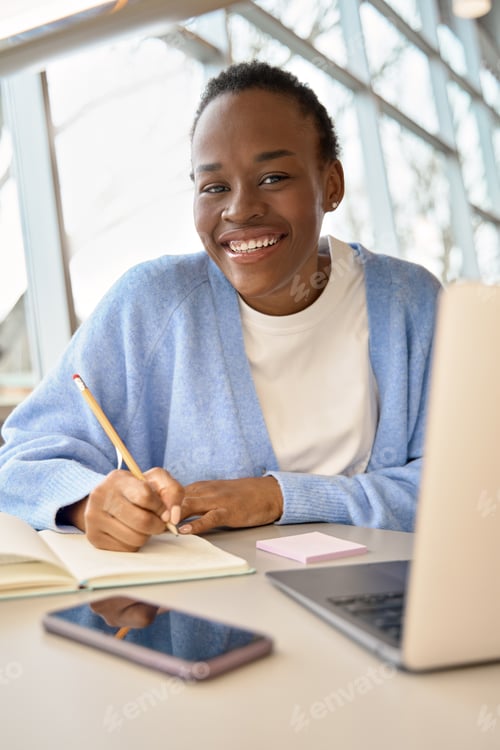 Preview: Happy African girl student using laptop learning online. Vertical portrait