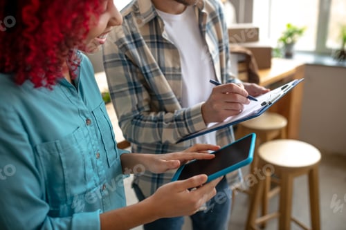 Preview: Man with notebook and pen, girl working with tablet.
