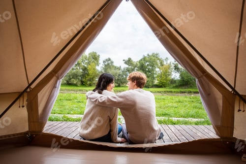 Preview: A couple sitting near a tent at glamping