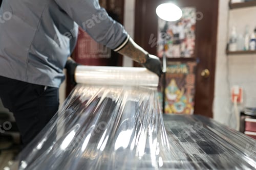 Preview: A tattoo artist is covering his studio stretcher with plastic film