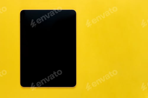 Preview: Black digital tablet on bright yellow background, top view, flat lay with copy space