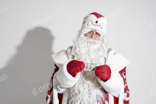 Preview: father frost in long warm coat, red mittens and a hat holds money in his hands