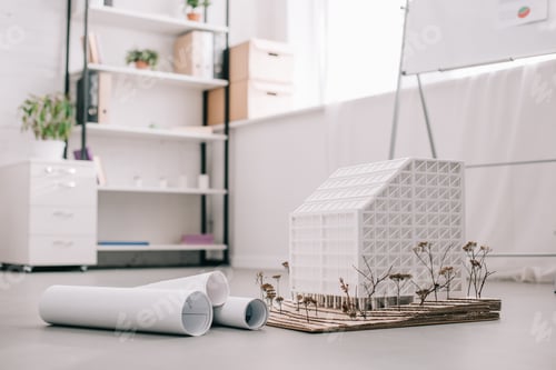 Preview: modern architect office design with blueprints and house model on foreground