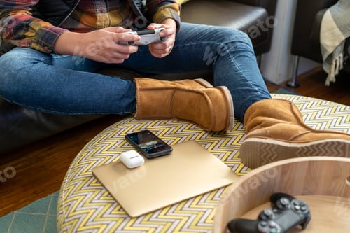 Preview: Young women at home relaxing playing video games in her lounge room while wearing slippers
