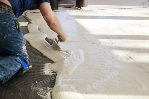 Preview: Prepare to tiles on the cement floor technicians are mixing cement in troweling adhesive onto a