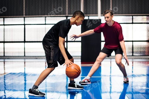 Preview: Two teenage boys playing basketball together on the court