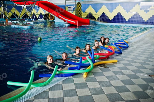 Preview: Fitness group of girls doing aerobical excercises in swimming pool