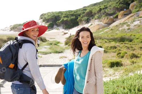 Preview: Two women friends walking to the beach with bag and clothes