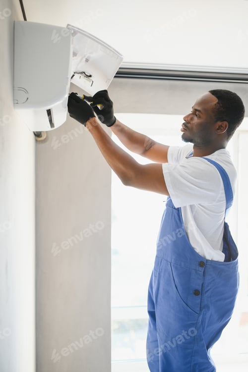 Preview: African American electrician repairing air conditioner indoors