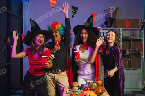 Preview: Dinner and group of people celebrating together at Halloween party.
