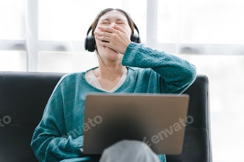 Preview: Smart and positive Asian female freelancer or student getting sleepy during online webinars or home