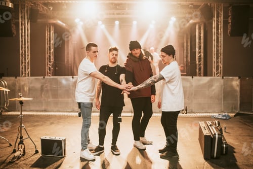 Preview: Band stacking hands before a concert