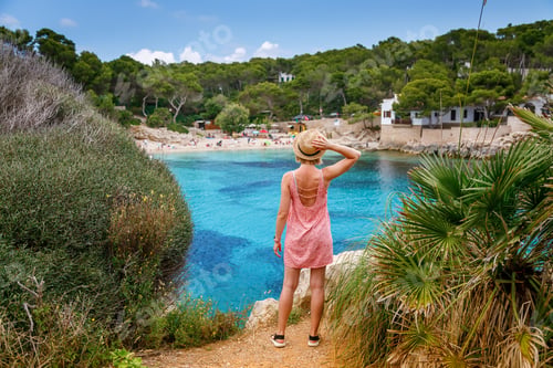 Preview: A woman enjoying a peaceful moment on a cliff, overlooking Cala Gat beach in Mallorca