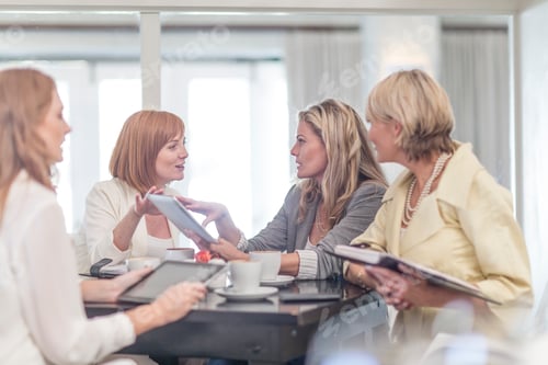 Preview: Business woman using digital tablet at business lunch