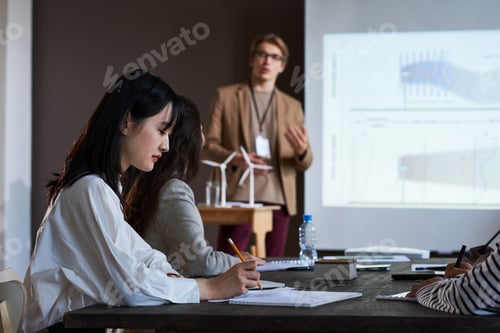 Preview: Businesswoman sitting at conference with people
