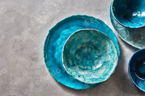 Preview: Porcelain blue bowls and plates on a gray table . Colorful ceramic vintage handmade dishes. Flat lay
