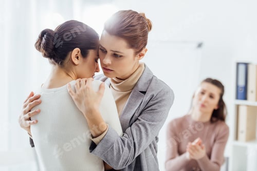 Preview: selective focus of woman embracing another woman during therapy meeting
