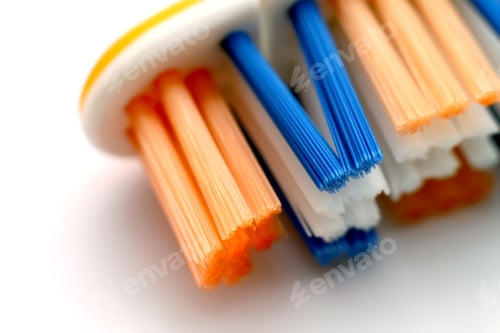 Preview: New toothbrush with yellow, blue and white bristles on the plastic base