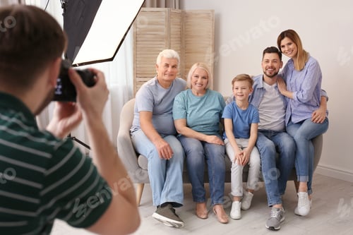 Preview: Professional photographer taking photo of family on sofa in studio