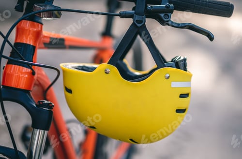 Preview: Protective helmet hanging on bicycle handlebar