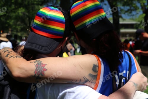 Preview: Queer couple from behind at Pride festival.