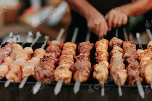 Preview: Frying shish kebab on the skewers in brazier. Fresh ruddy meat for barbecue grill on fire outdoor.