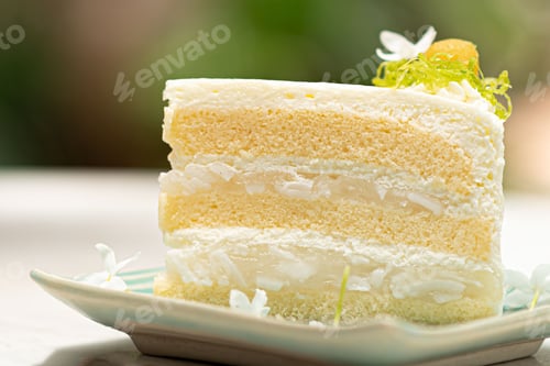 Preview: Deliciously presented piece of white vanilla cake sits atop a plate with flowers