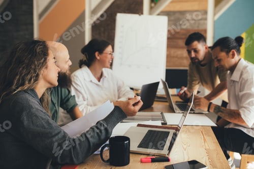 Preview: Group of young people designers having meeting in a modern office.