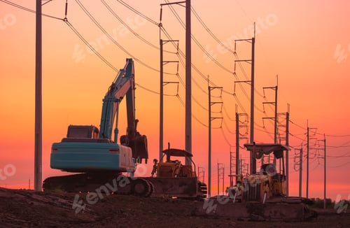 Preview: Silhouette of excavator and 2 bulldozers parked on country road with row of electric poles at sunset