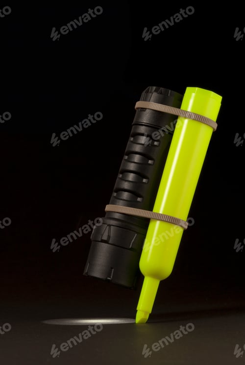 Preview: A neon green flashlight laying on its side against a dark background
