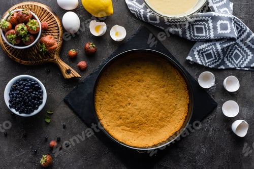 Preview: flat lay with pie dough, cream in bowl and fresh berries on dark grey tabletop