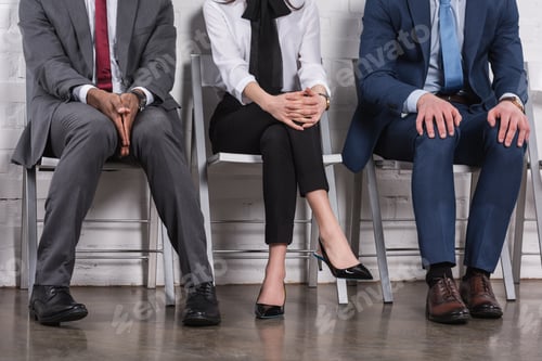 Preview: partial view of multiethnic business people sitting on chairs while waiting for job interview