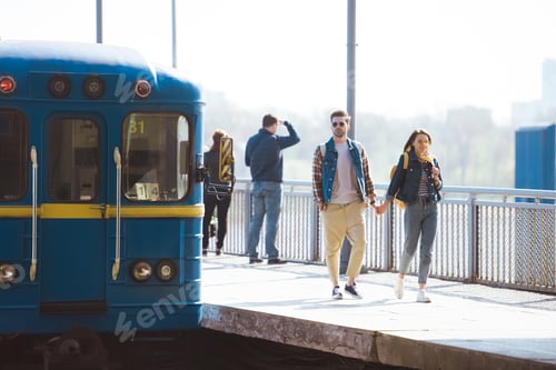 Preview: stylish couple of tourists going at outdoor subway station