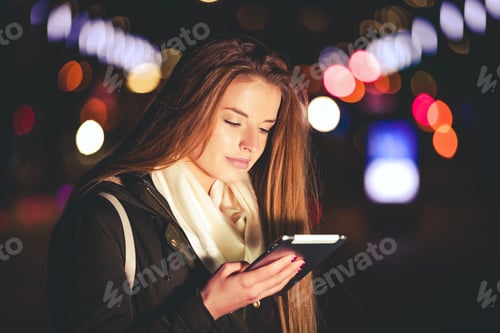 Preview: Beautiful woman using tablet in the city at night