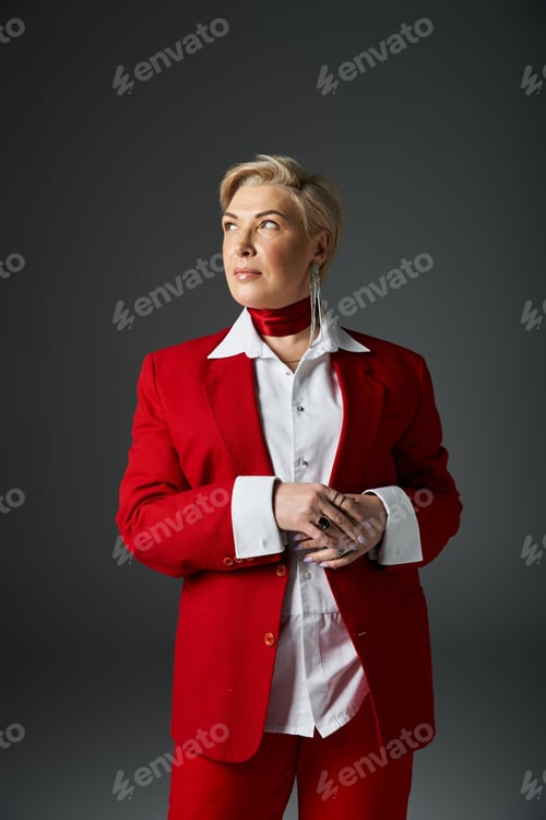 Preview: Stylish adult woman in elegant red suit poses confidently against a minimalist backdrop in WC AS
