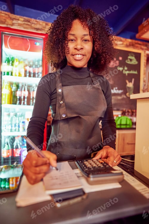 Preview: Smiling cashier working at cafe checkout counter and doing inventory