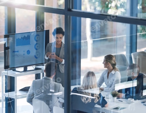 Preview: Shot of a businesswoman discussing information with businesspeople in the boardroom