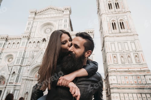 Preview: Couple sharing a tender moment in front of a grand cathedral