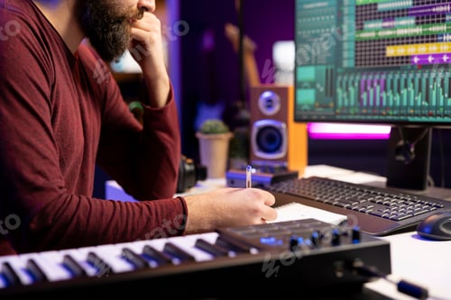 Preview: Musician composing new song in his home studio and taking notes