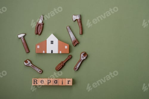 Preview: Repair or home improvement tools and a house model on a plain background