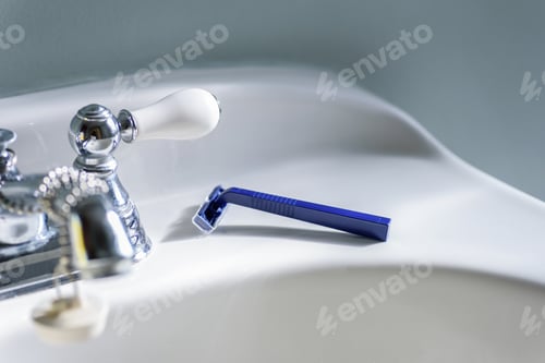 Preview: Blue razor on white bathroom sink