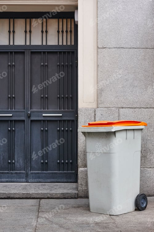 Vista previa: Garbage can on an urban building entrance door. Clean environment